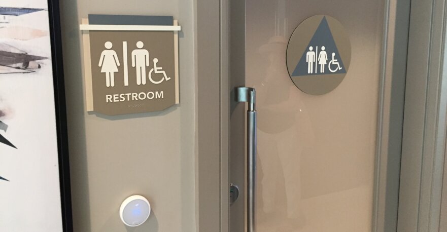 Photography of signage marking an ADA compliant bathroom entrance